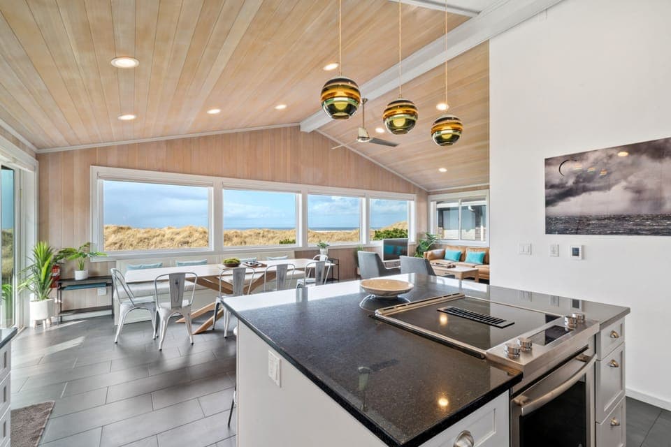 The open kitchen, dining, and living areas are bathed in light and views.