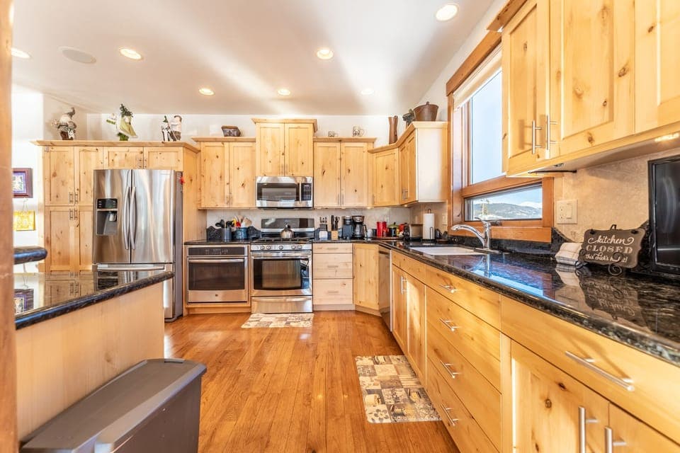 Spacious updated kitchen with modern stainless steel appliances, granite countertops and small flat screen TV.