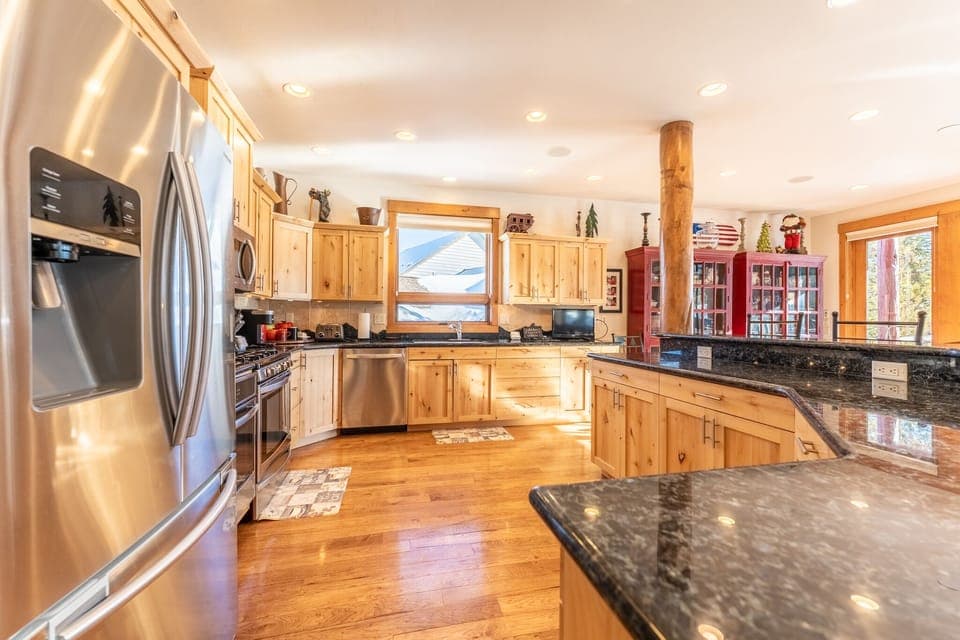 Spacious updated kitchen with modern stainless steel appliances, granite countertops and small flat screen TV.