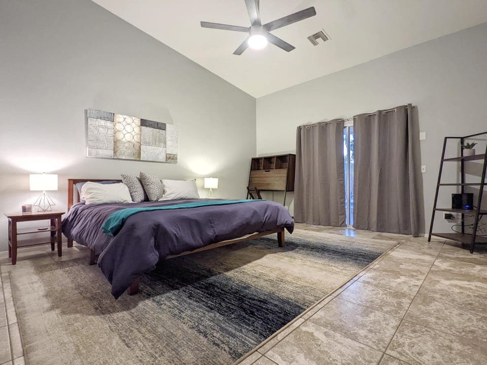 Master bedroom with king bed and desk workstation, private doors to pool deck