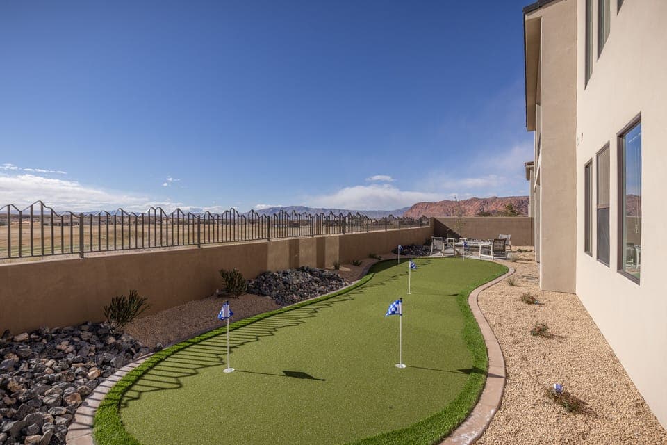 Putting green - This back view highlights the spacious back yard and private putting green.