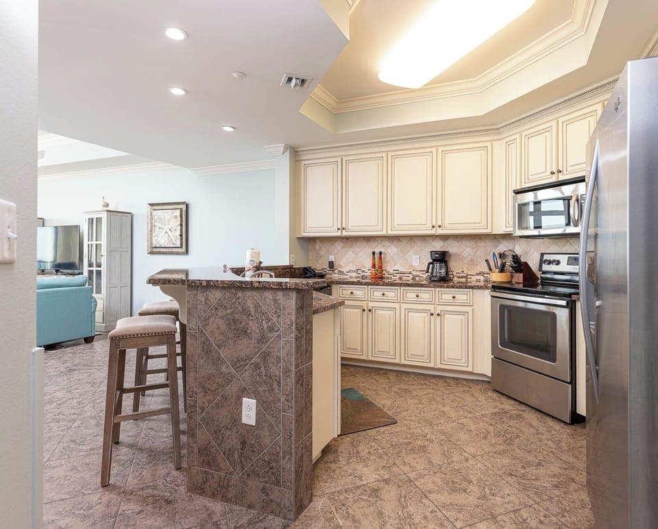 This kitchen features stainless appliances, granite countertops, and a cozy breakfast bar, perfect for morning coffee