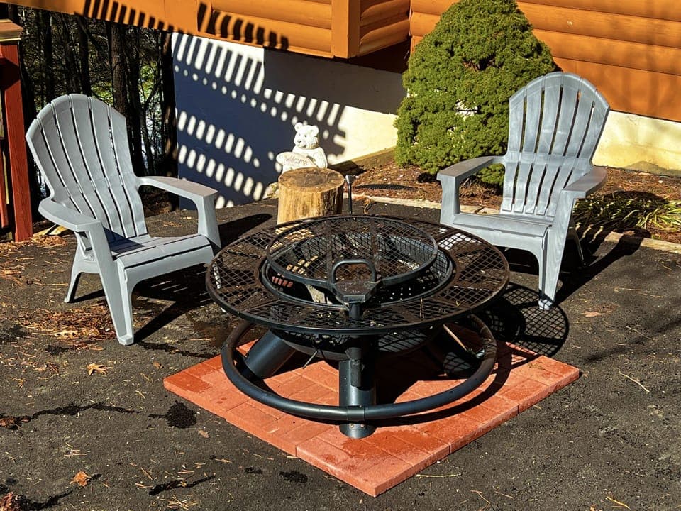 Fire pit area on driveway with two Adirondack chairs 