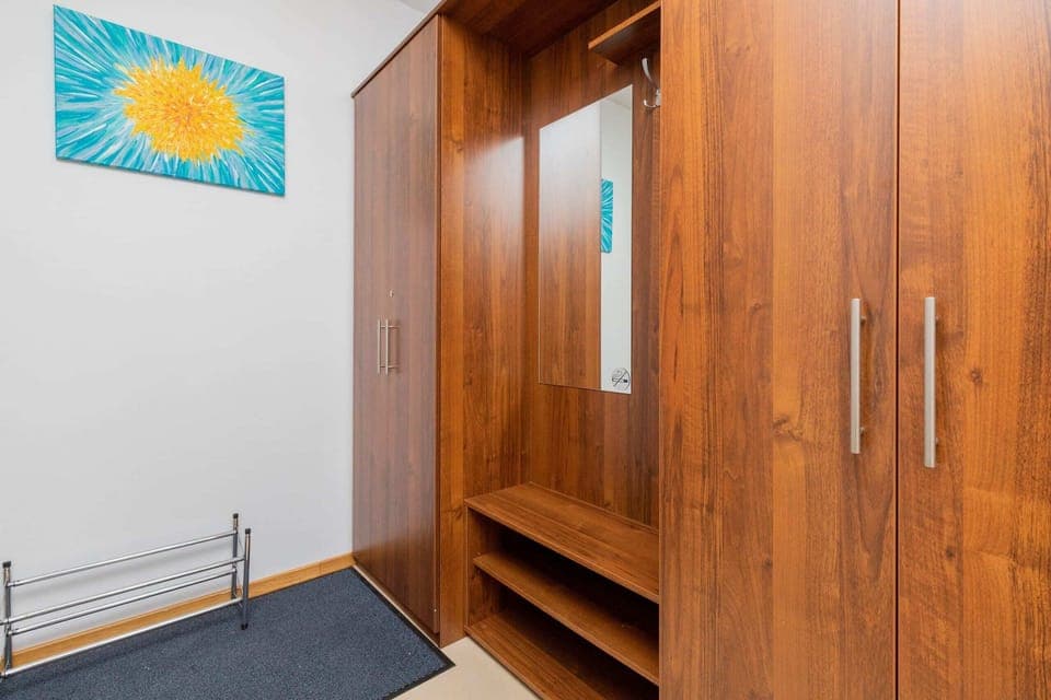 A wooden closet and bench area near the entrance, providing functional storage space and seating for convenience.