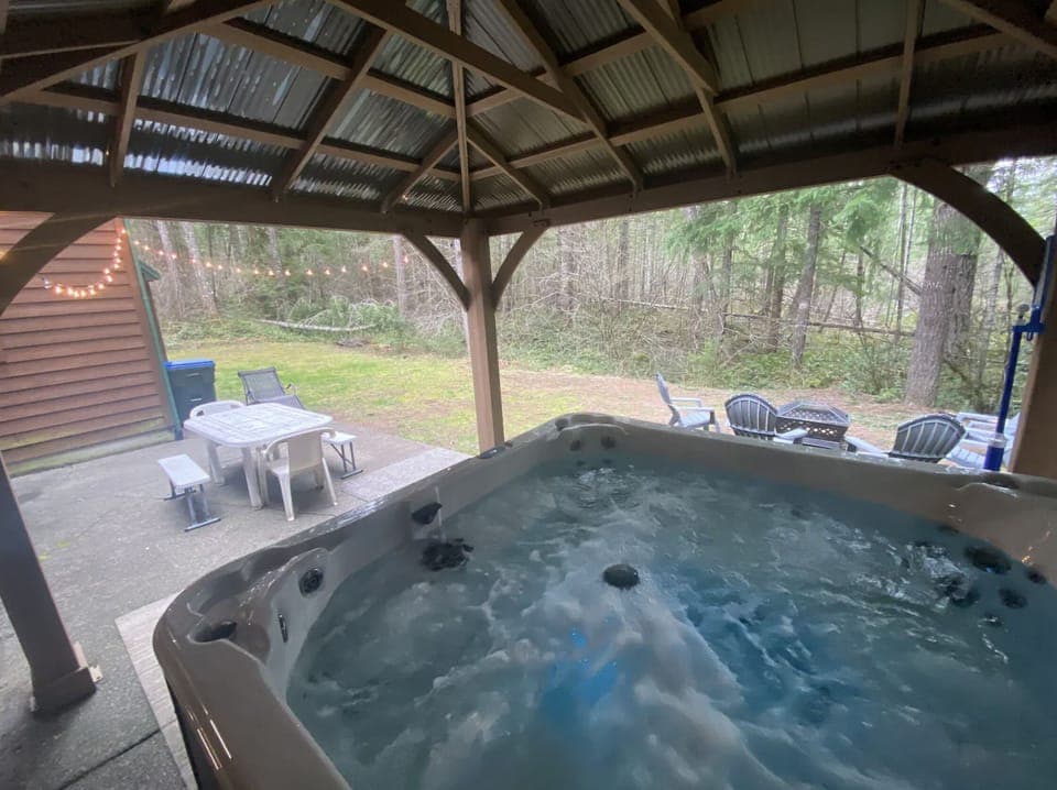 Large covered hot tub overlooking the private back yard and patio