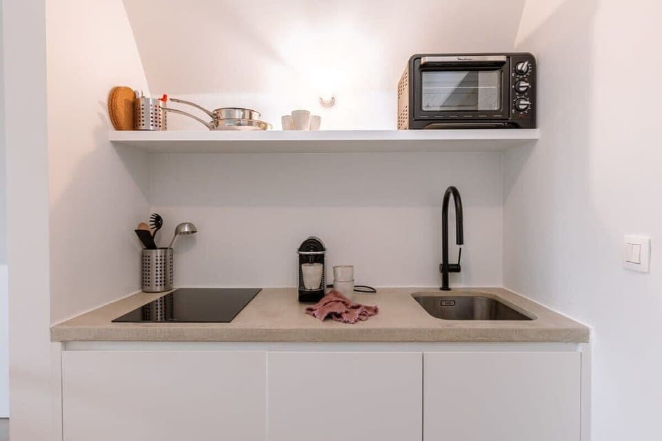 Compact kitchen with minimalist design and soft tones
