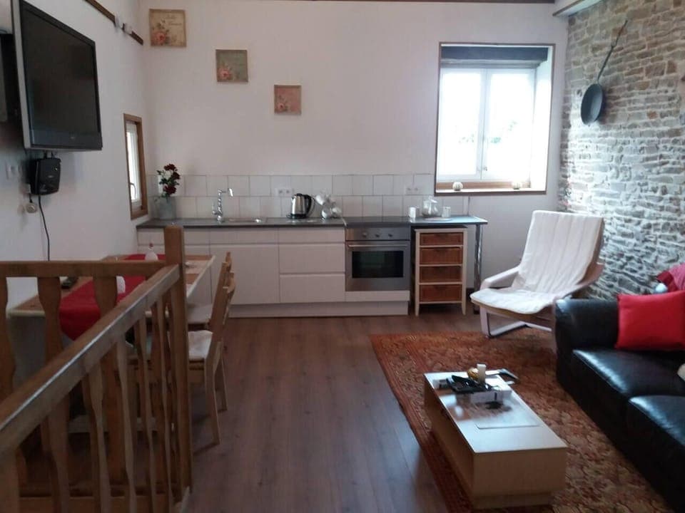 The kitchen area has a cooker, fridge and utensils along with a toaster, kettle and coffee machine