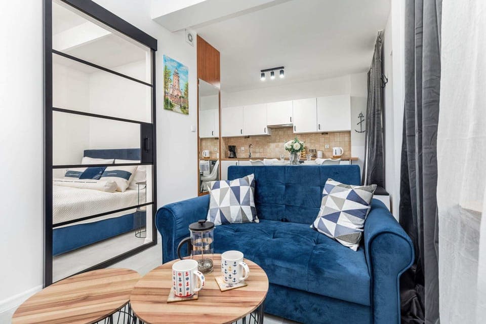 A cozy living room with a navy blue sofa, decorative pillows, and a modern coffee table.

