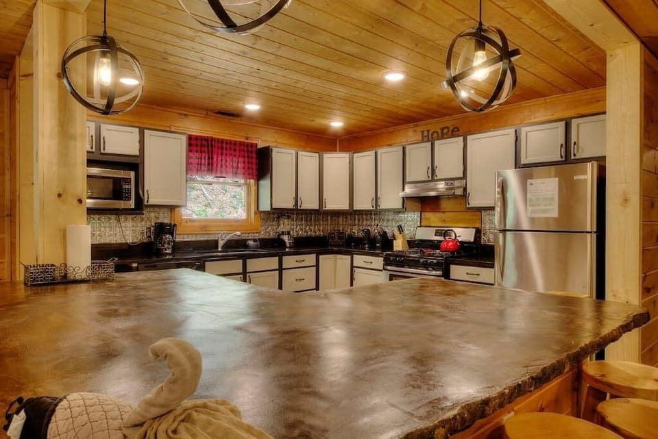 Modern, open-style kitchen with counter seating. All kitchen essentials are provided, including 12 cup coffee pot, crockpots, rice cooker, blender, children plates/cups/silverware, and more. 