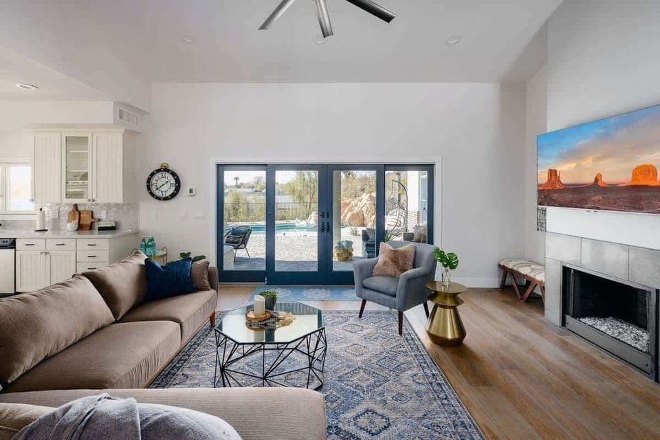 Bright and open living area with flat screen TV, and designer furnishings. *Fire place for display only