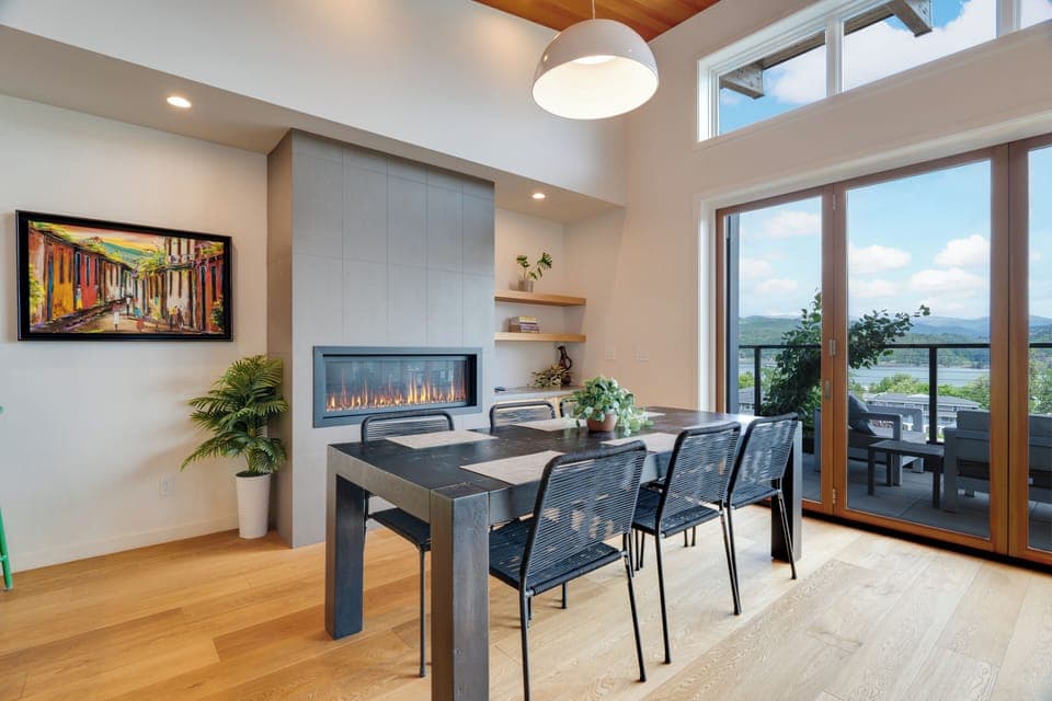 dining room with gas fireplace and games on top floor adjacent to covered deck.