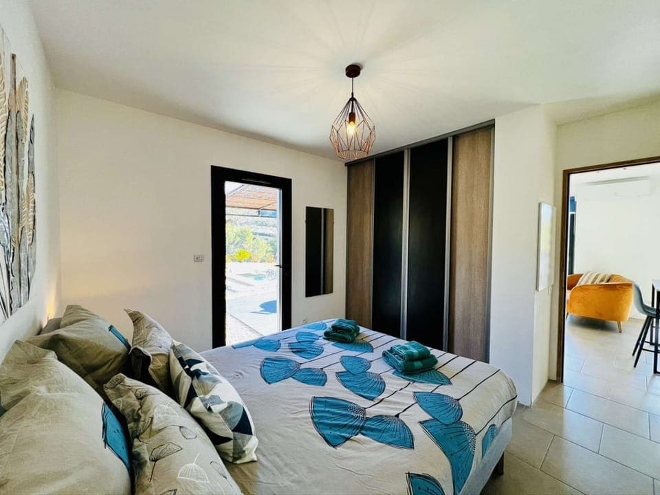 the bedroom with its large 160x200 bed, dressing room and view of the private swimming pool