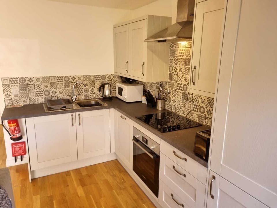 Modern kitchen with washing machine, dishwasher, fridge freezer, oven, microwave