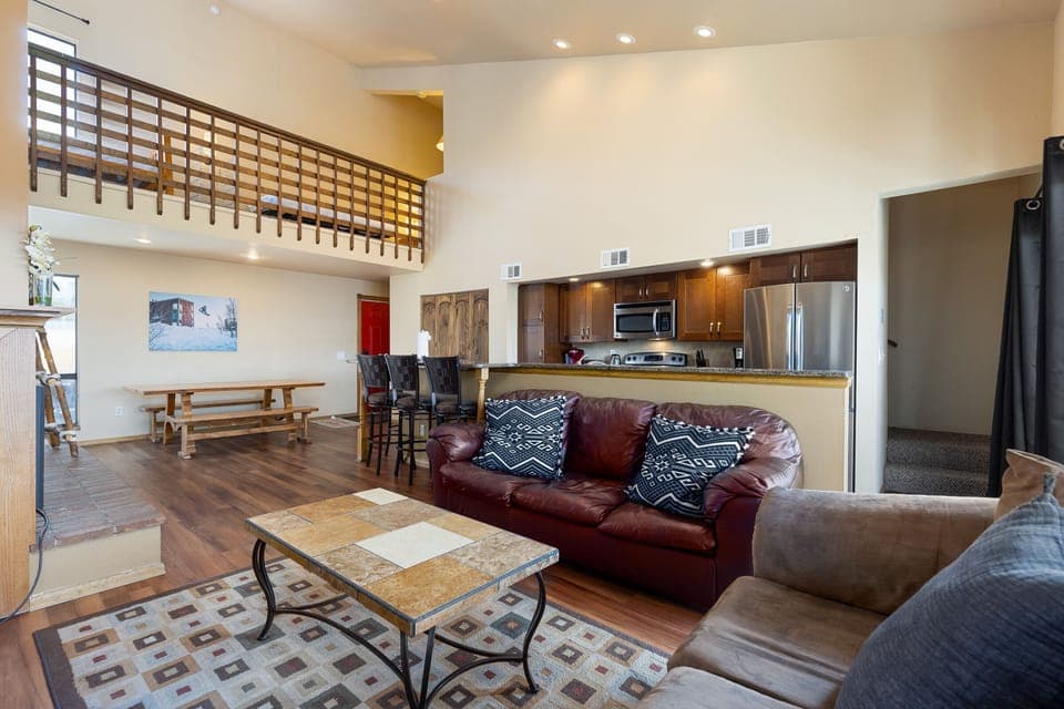 Spacious living area with large smart TV, gas fireplace, hardwood floors and ample seating.