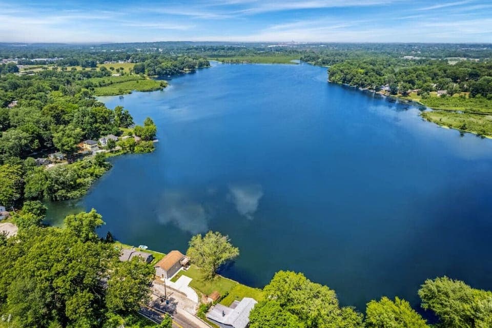 Aerial view of lakefront surrounded by trees   - Scenic waters with peaceful natural setting   - Perfect location for fishing, kayaking, or views