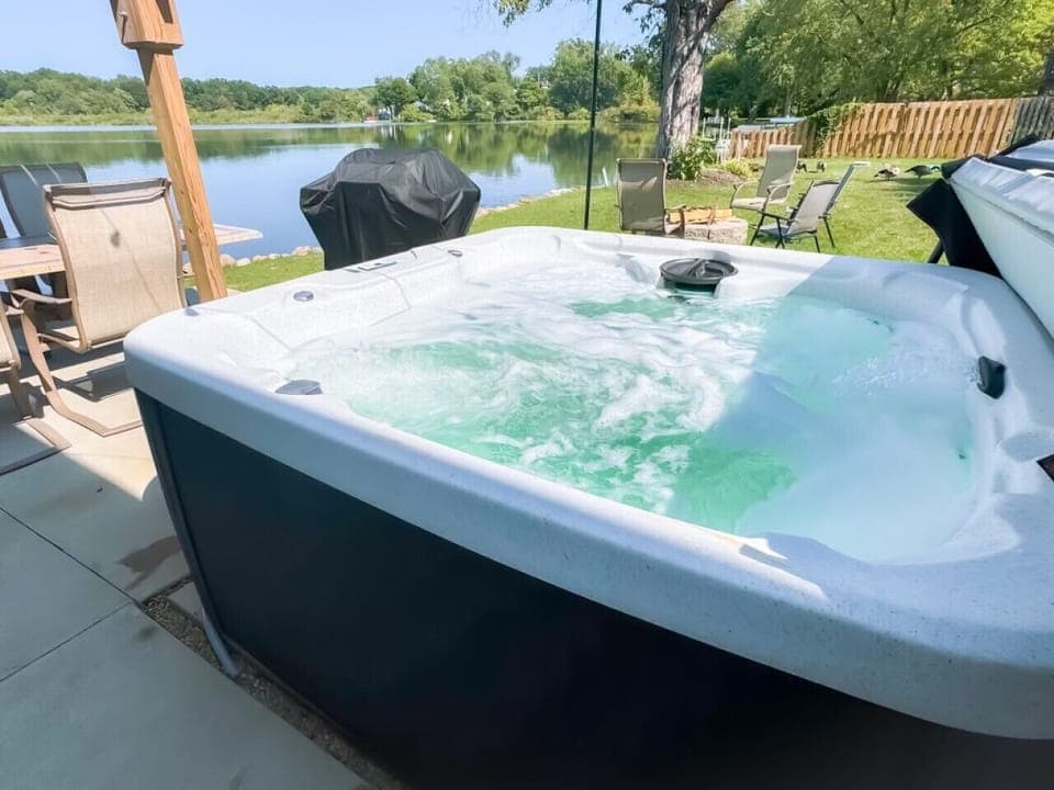 Relax in the private hot tub with bubbling waters   - Take in serene lakefront views while you unwind   - Perfect outdoor spot for evening gatherings by the grill