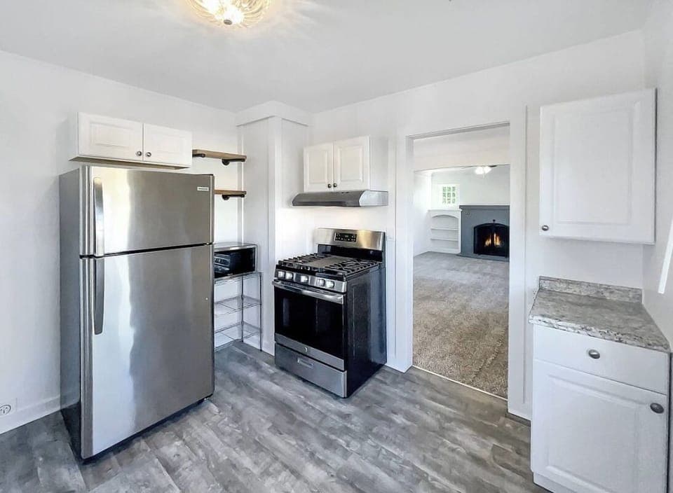 Kitchenette area includes fridge, gas oven/stove, microwave, portable dishwasher