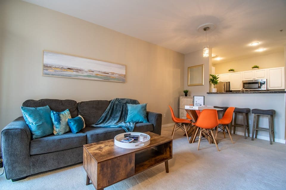 Spacious living room with a 65" tv, sleeper sofa and beautiful garden views