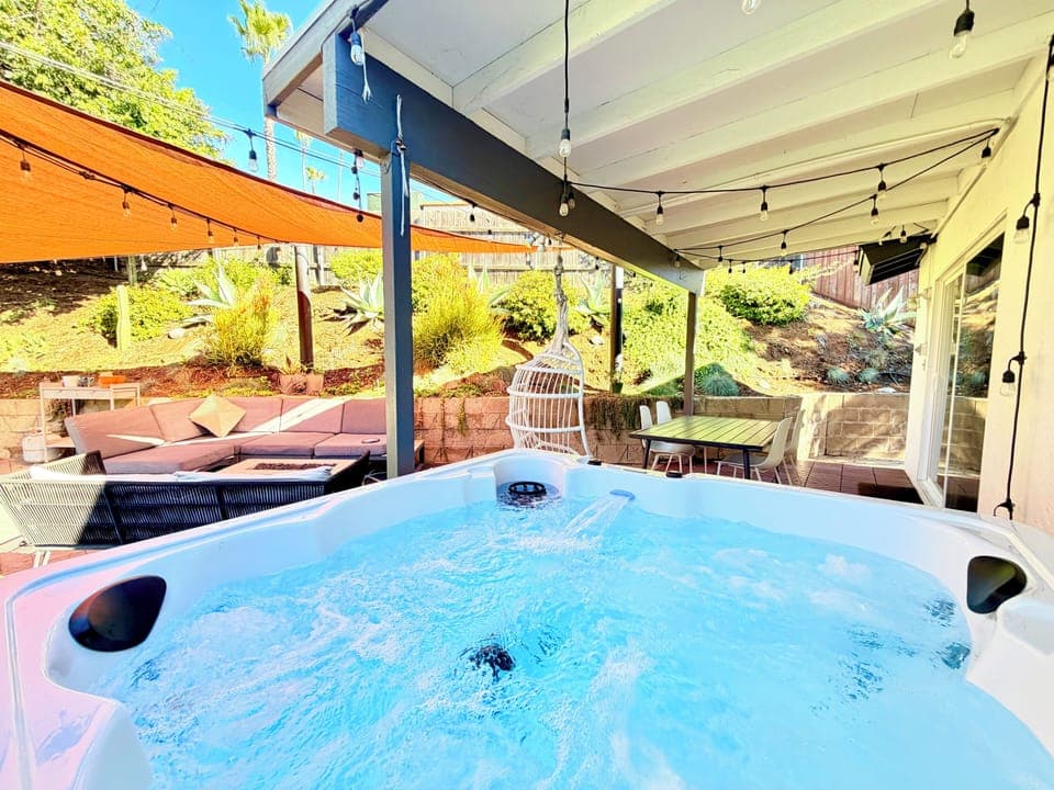 Private backyard with hot tub, dining table, lounge with fire pit, and BBQ Grill
