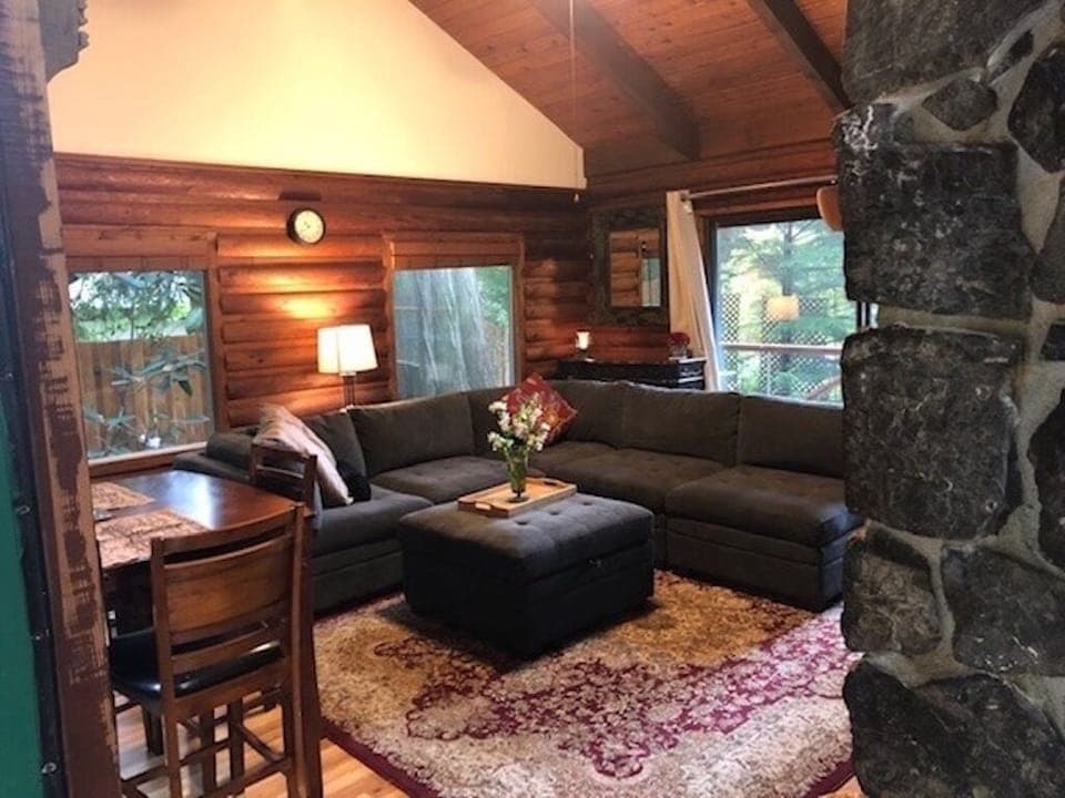 Cozy Living room with exposed beam vaulted ceilings and windows on 3 walls.
