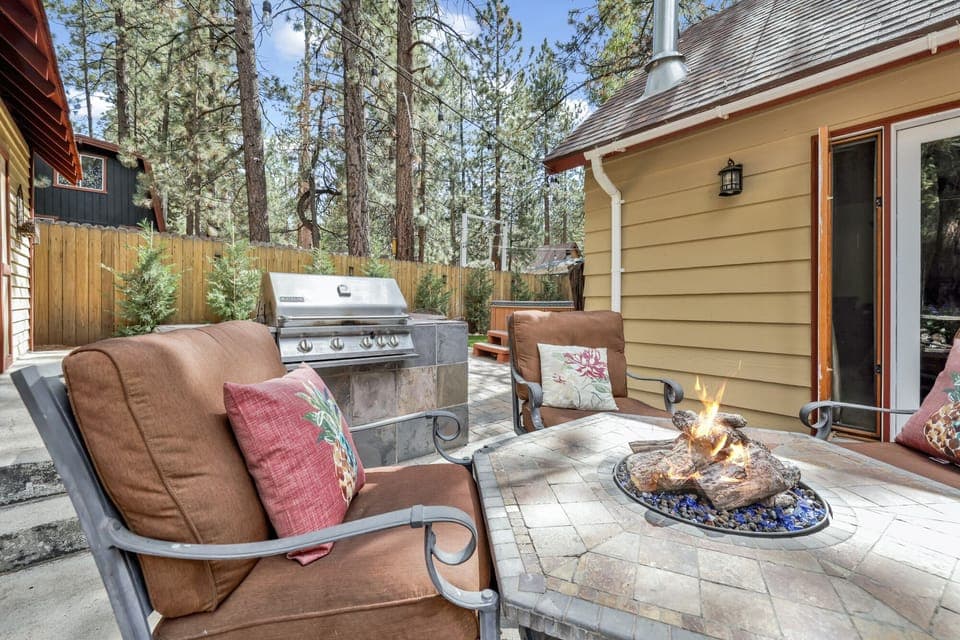 Private outdoor hot tub, with comfortable seating and a BBQ, surrounded by tall pines, perfect for relaxing under the trees after a day of adventure—enjoy peaceful forest views, fresh air, and a truly rejuvenating stay.
