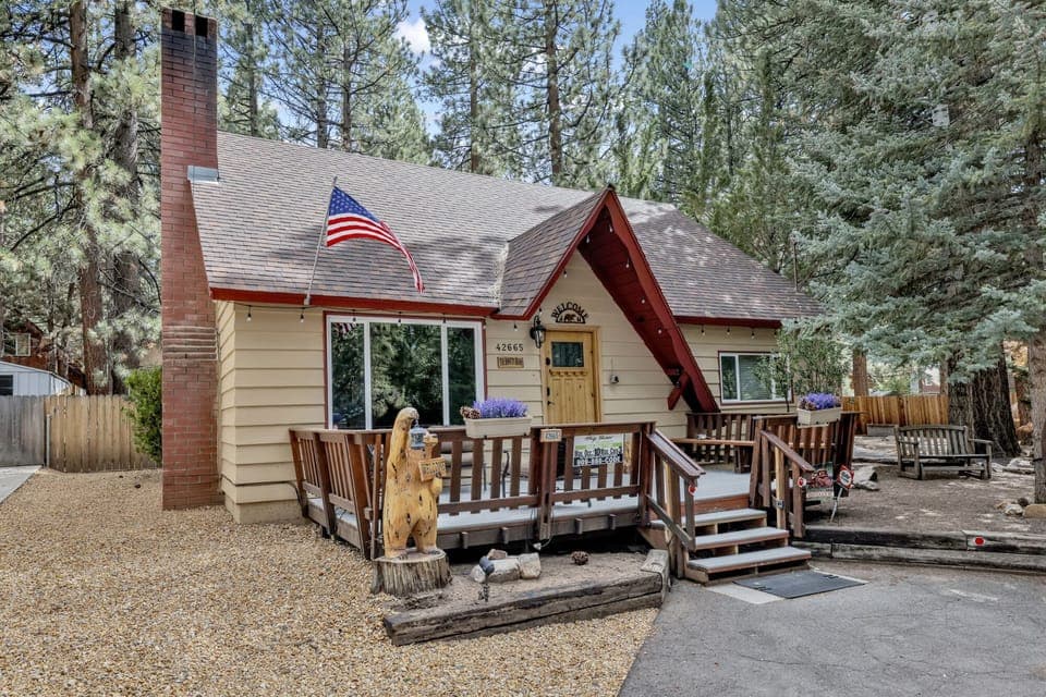 Welcoming cabin entry surrounded by towering pine trees, offering fresh mountain air and a peaceful forest setting—the perfect first impression for your Big Bear Lake getaway.