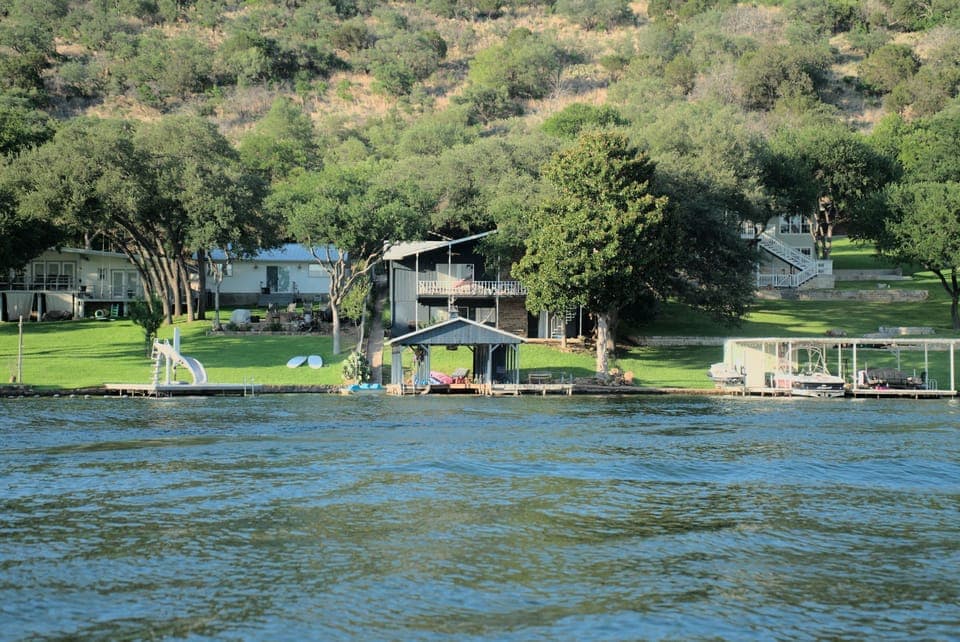 House and boat dock in center, view from across cove.