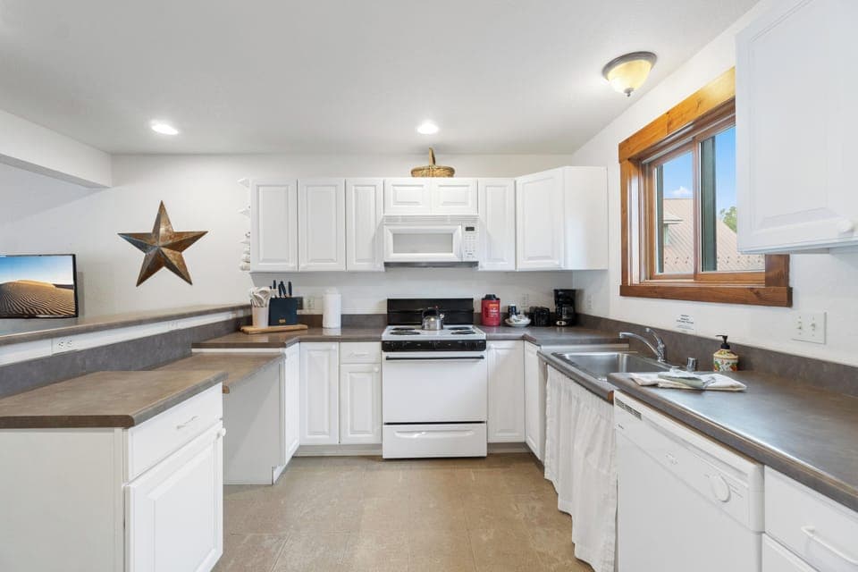 A fully equipped kitchen with a breakfast bar for casual dining or morning coffee.
