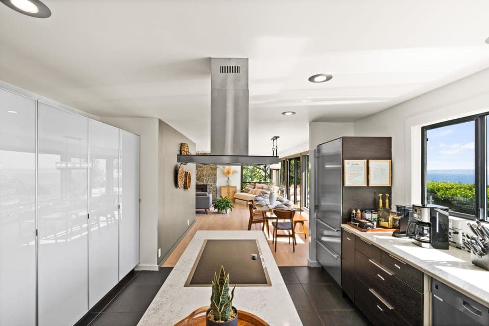 Fully stocked modern kitchen with induction stove top, double oven, coffee bar.