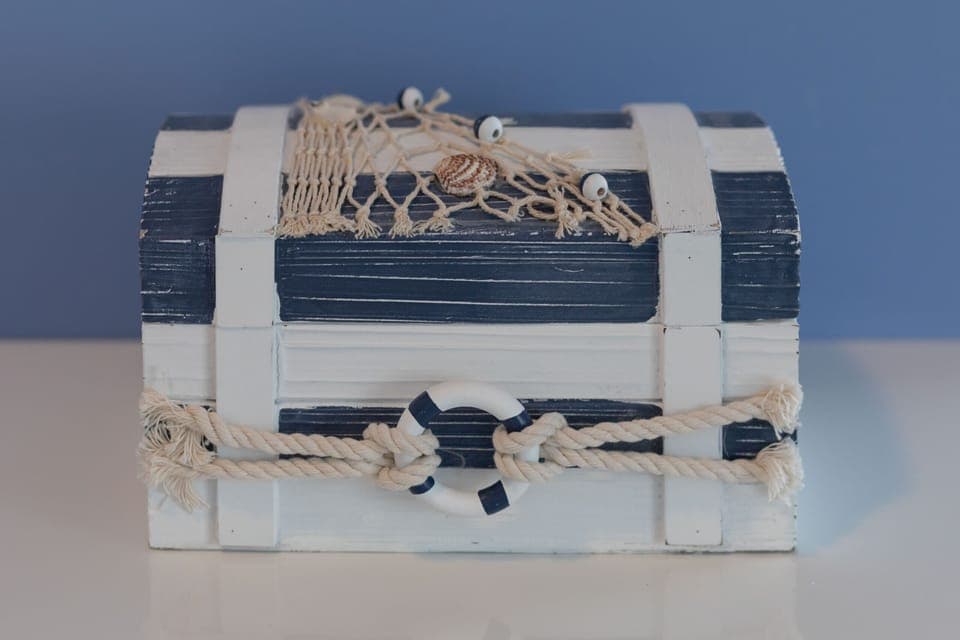  A close-up of decorative nautical-themed baskets neatly stacked for storage. The woven material adds a cozy, natural element.