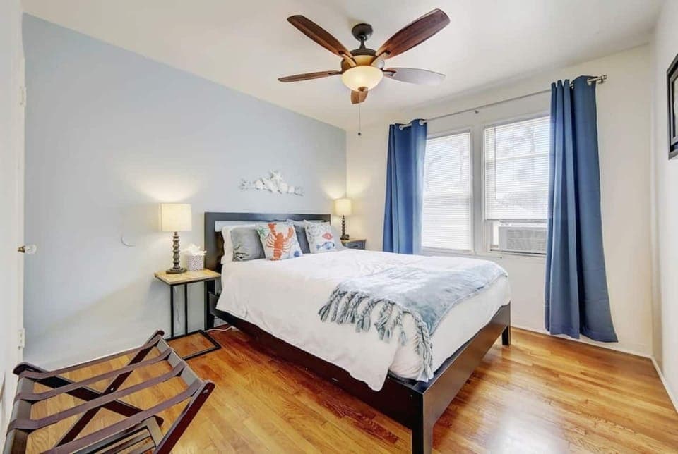 Brightly lit bedroom off the living room with a comfy queen size bed and plenty of space. 