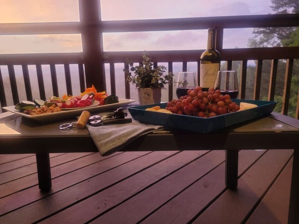 Enjoy a cozy evening on the deck with wine and charcuterie, surrounded by nature and serene views.