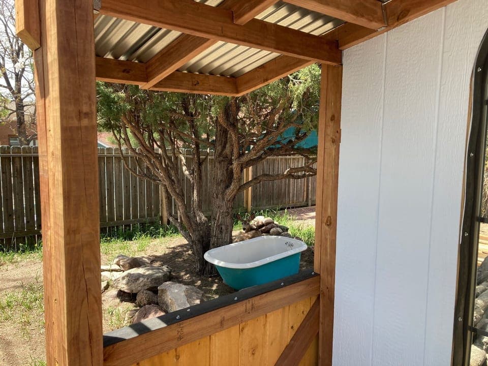 A peak through the gazebo. There is a deer behind the bathtub