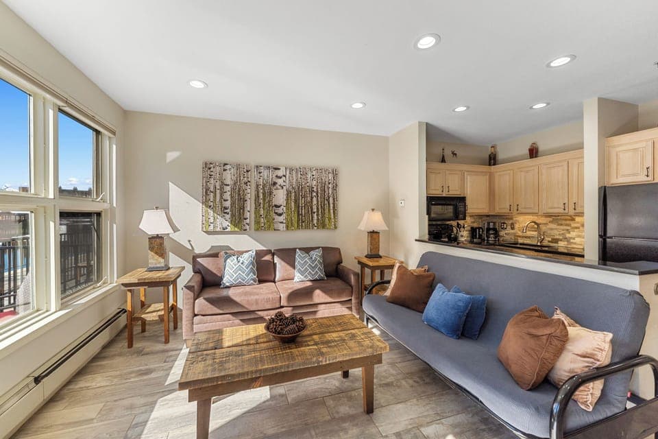Living area featuring updated furnishings, gas fire place, mounted smart TV, and beautiful views of the lake and mountains.