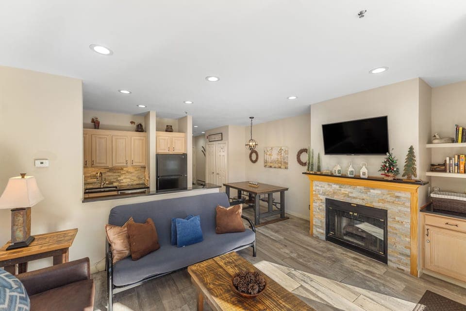 Living area featuring updated furnishings, gas fire place, mounted smart TV, and beautiful views of the lake and mountains.