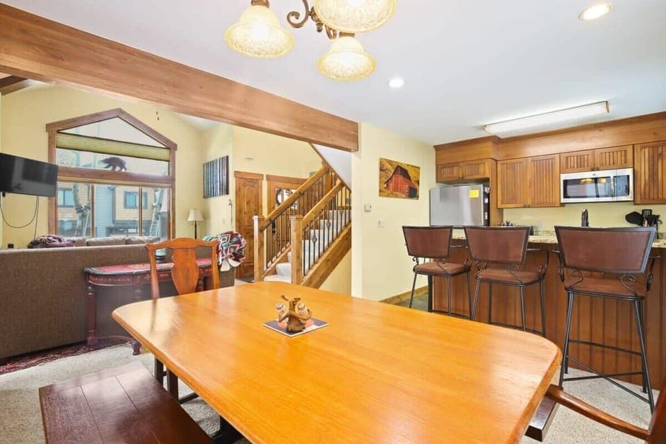 The dining room table can accommodate six, with seating for four more at the bar area that serves as an ideal bridge between the kitchen and dining areas, allowing for easy serving and socializing thanks to the open layout of this home.