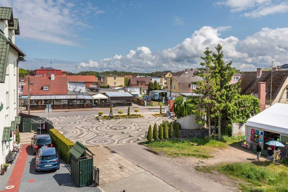 An exterior view of the picturesque neighborhood with traditional architecture and greenery.
