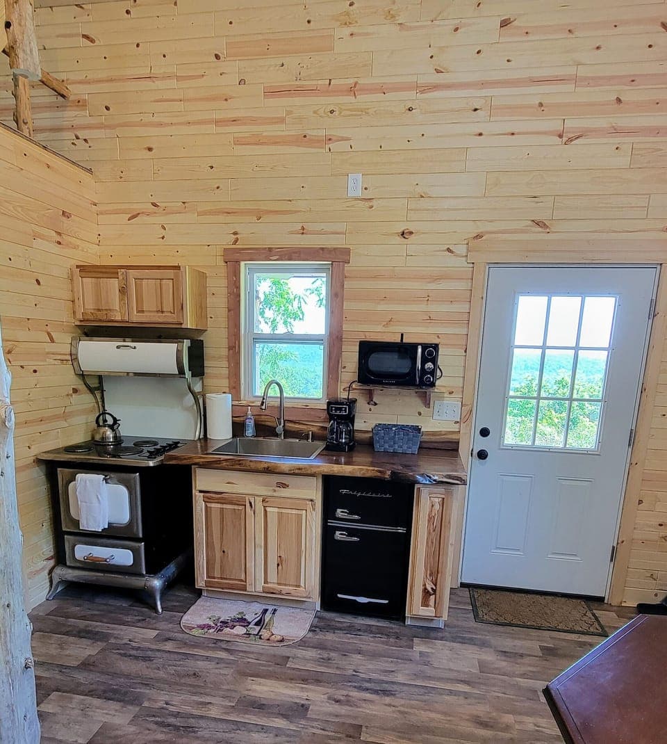 Kitchen with tea kettle, coffeemaker, microwave, mini fridge/freezer, and oven