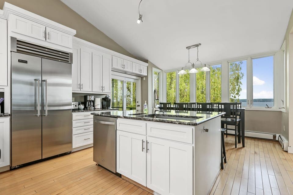 large fridge and deep farm sink basin.  Table looking out at the lake sits 8.