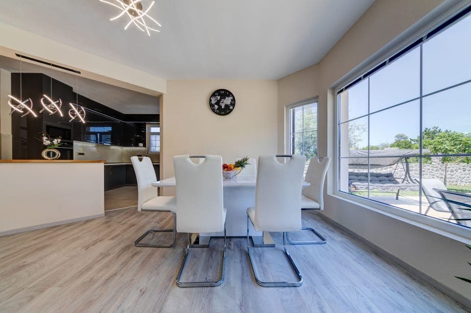 Dining area with a view of the garden and pool. 