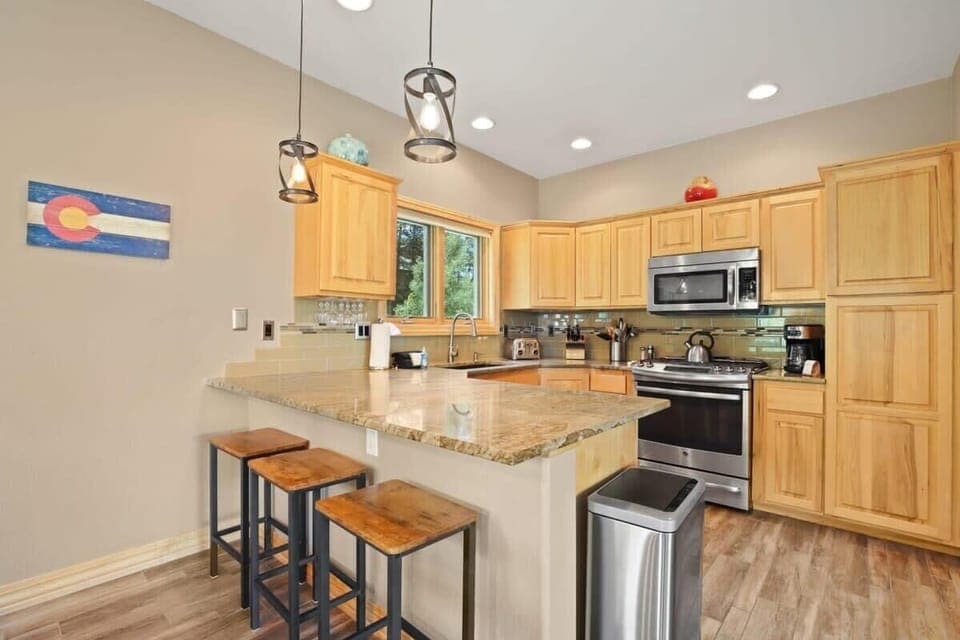 The stunning kitchen boasts stainless steel appliances, granite countertops and abundant cabinet space. It is stocked with everything you need to whip up a meal, including a blender, toaster, tea kettle and coffee maker.