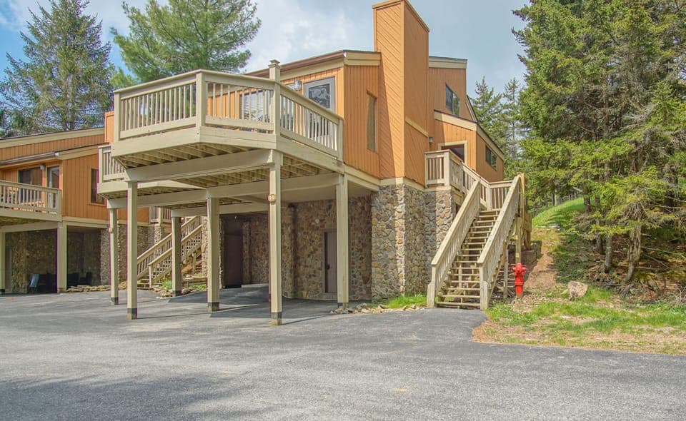 Covered parking with steps leading up to the entrance to the unit