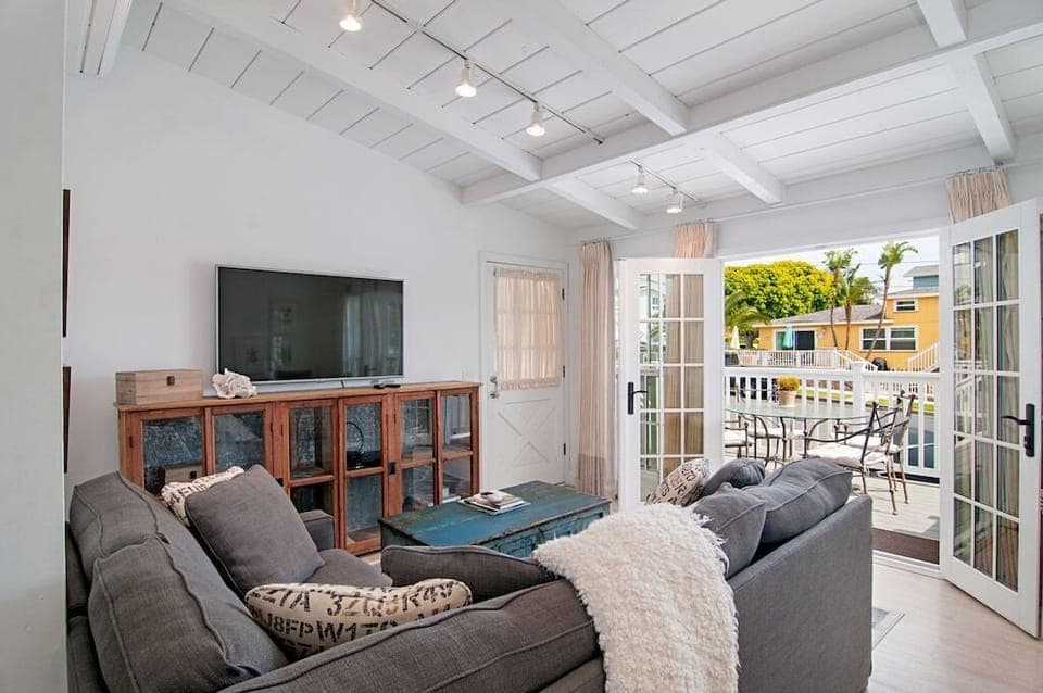 View ofliving space with large flat screen TV and outside deck.