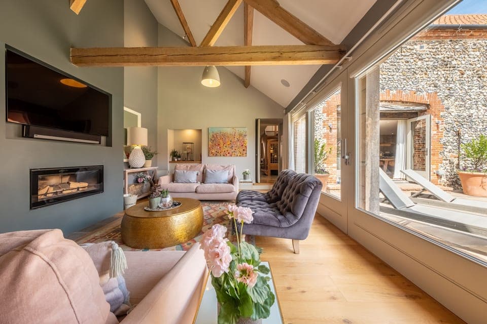 Horse Yard Barn, Warham: Sitting room with wood burning stove and bi-fold doors to outdoors