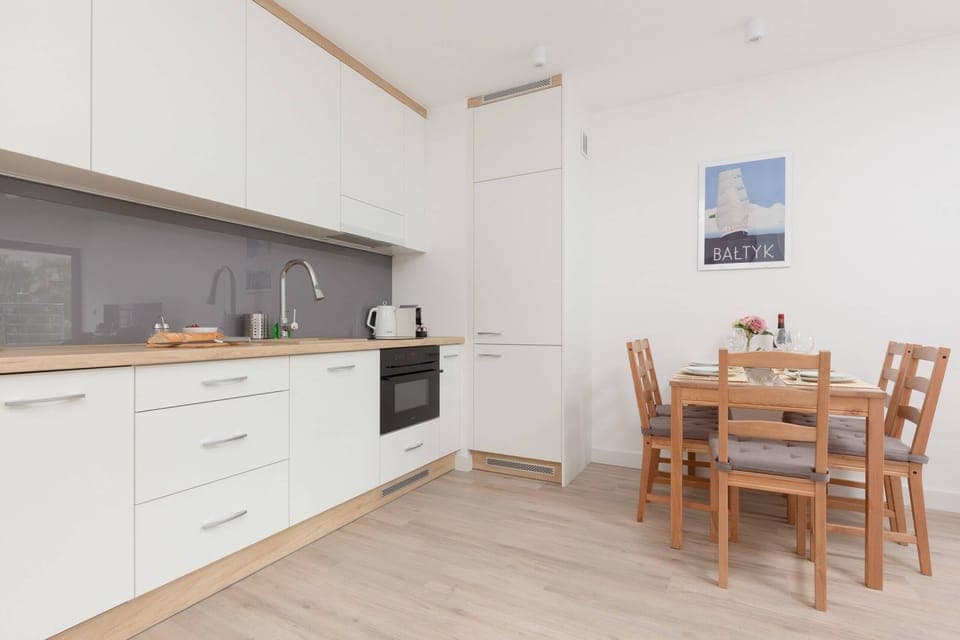A kitchen with white cabinetry, a built-in oven, and ample counter space, blending functionality with a simple aesthetic.