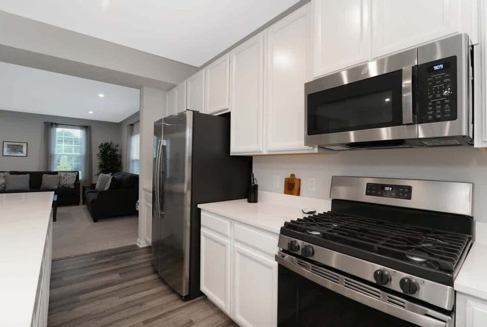 This elegant kitchen features stainless steel appliances, sleek cabinetry, and stunning countertops. The spacious layout, with a large island, is perfect for meal prep, casual dining, and hosting guests in a sophisticated, functional space.