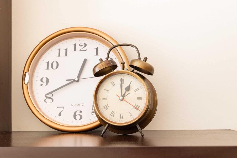 A close-up of a vintage clock on a wooden shelf, adding a touch of character to the room's decor.