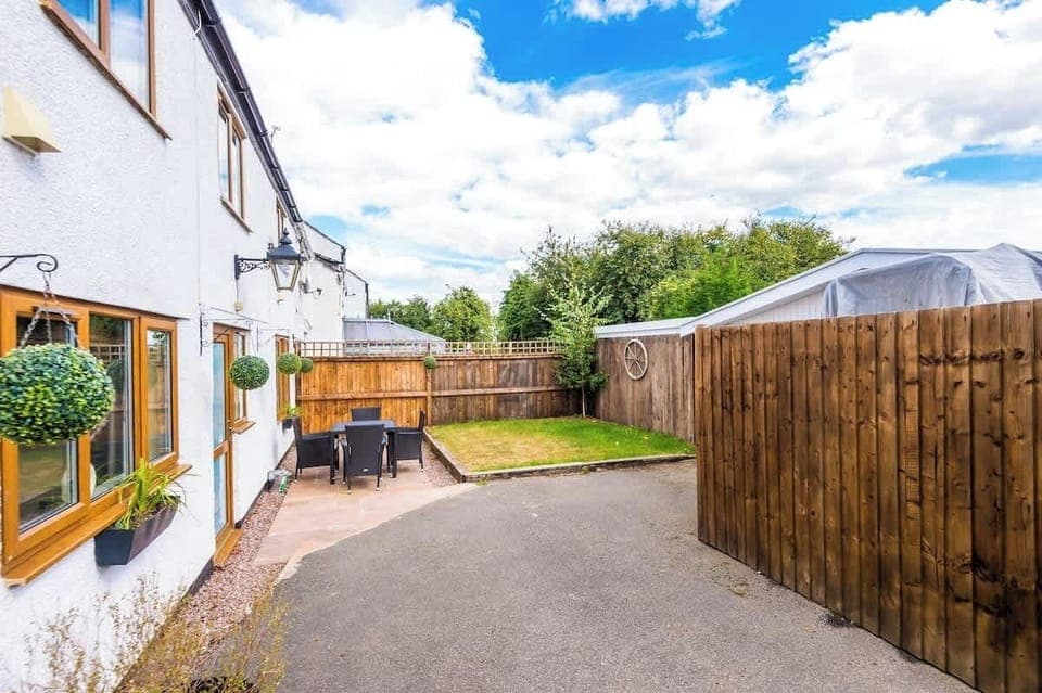 To the rear of the property, there is a patio with outdoor furniture, a small grass garden and ample parking.