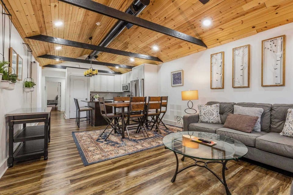 Bright, open living room with vaulted wood ceiling and cozy seating.