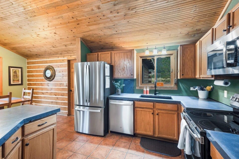 Fully equipped kitchen stainless steel appliances and concrete countertops.
